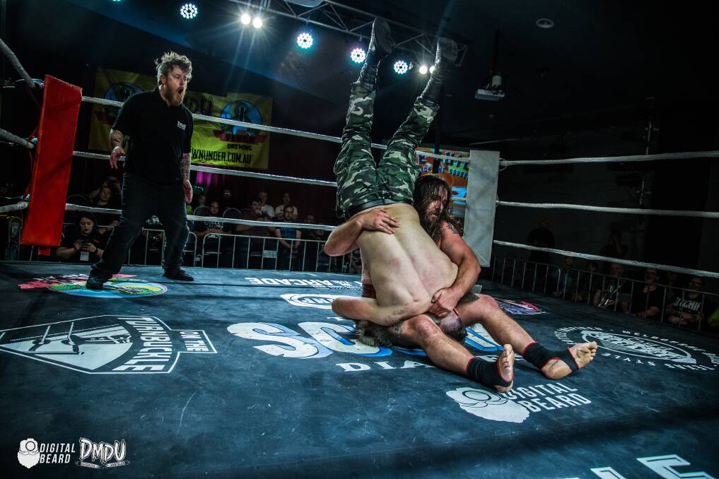 BUMP: Caveman Ugg piledrives Jake Taylor into the canvas at a recent Deathmatch Downunder event. Pictures: Digital Beard Photography