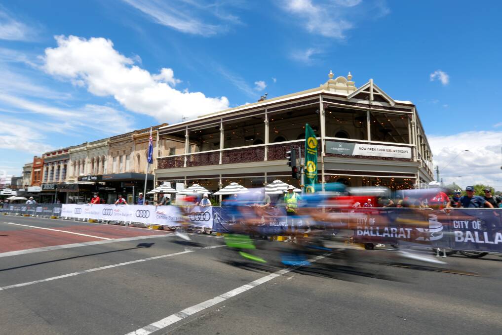 Competitors ride past the Golden City Hotel.