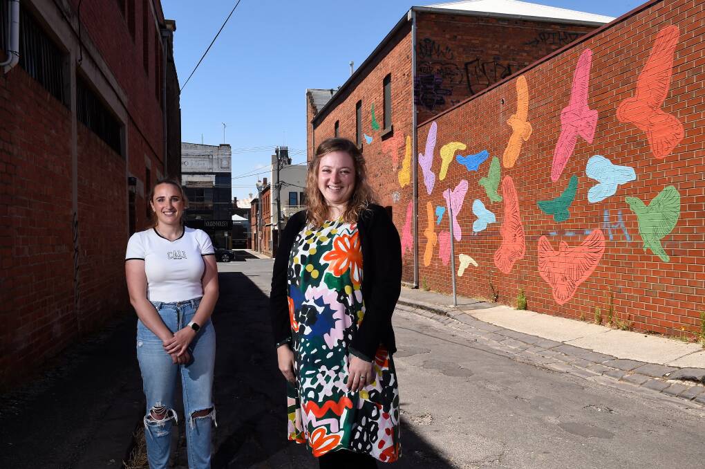 JOYFUL ART: City of Ballarat councillor Amy Johnson and artist Kelsie White in front of McKenzie Street laneway art. Picture: Adam Trafford 
