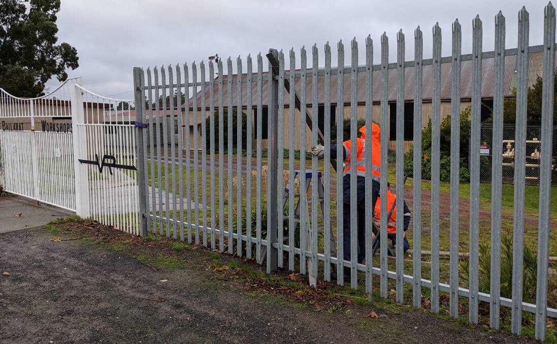 Alstom workers prop up the broken section of fence.