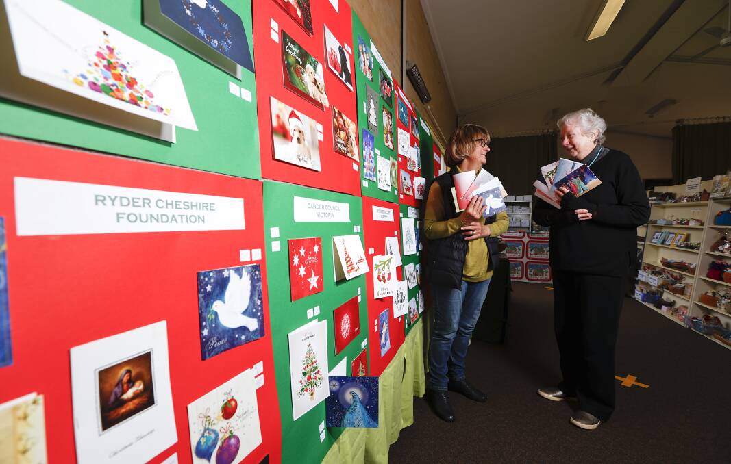 SANTA CLAUSE IS COMING TO TOWN: Denise Boyko and Pamela Foulkes with cards from the Ballarat Combined Charities Christmas Card Shop. Picture: Luke Hemer.