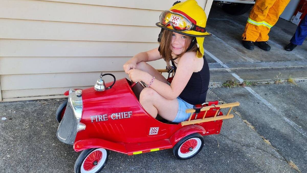 Ava Venn, 8, takes a ride in a vintage fire truck. Her grandfather and mum are both active members of the Beaufort brigade. Picture by Gabrielle Hodson.