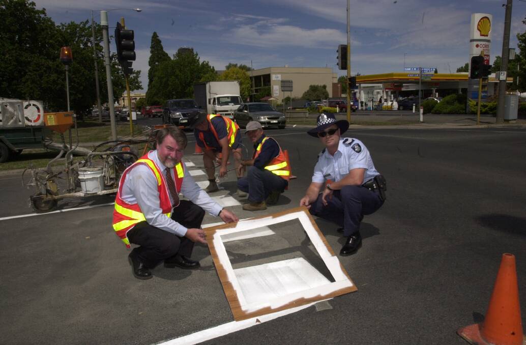 Line markings being changed at the intersection of Pleasant Street and Sturt Street in February, 2004. (Left) VicRoads Western Victoria regional manager Lance Midgley, council linemarkers (in background) Reg Goodwin and Arnold Viksna, and acting senior sergeant Ross Humphrey. Picture by Holly Curtis