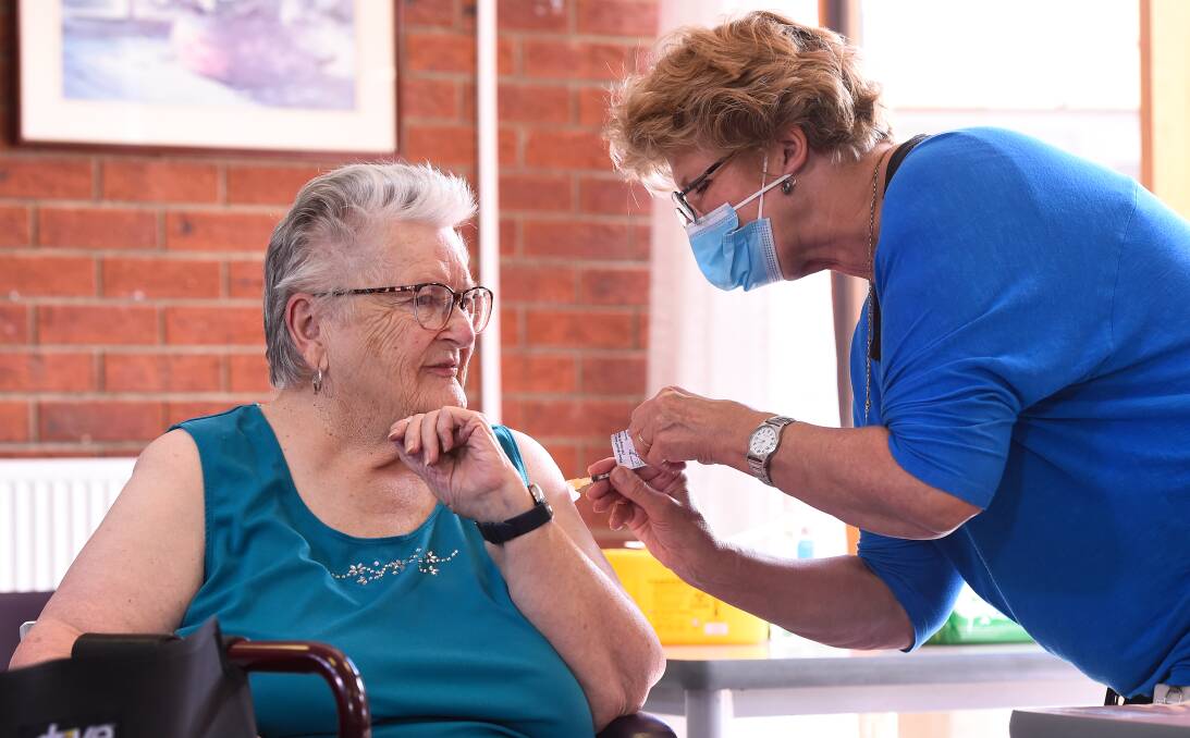 BHS aged care resident Joan Armstrong receiving her first vaccine dose from BHS nurse Carolyn Allen last year. Photo: Adam Trafford