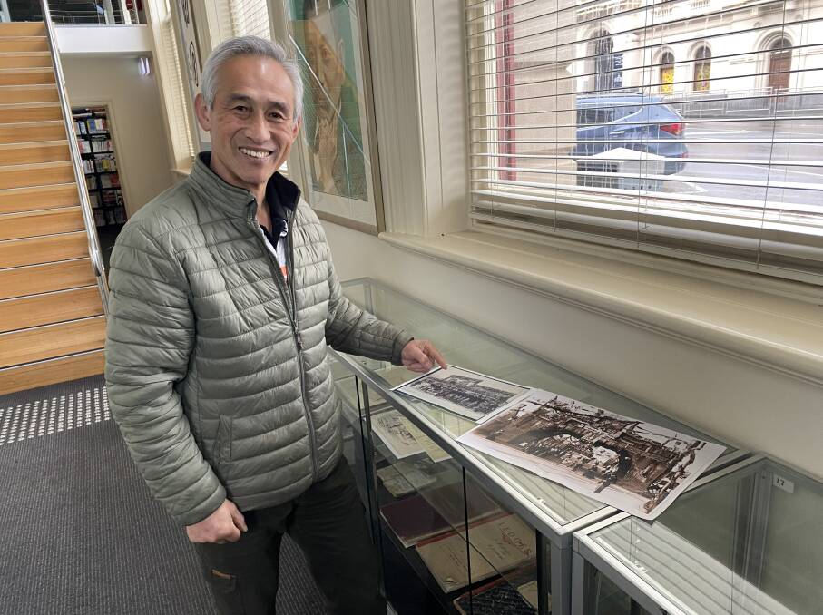 President of the Chinese Australian Cultural Society Ballarat Charles Zhang with copies of historic photos of the original Red Lion hotel and a Chinese welcome arch along Main Road. Picture by Maeve McGregor