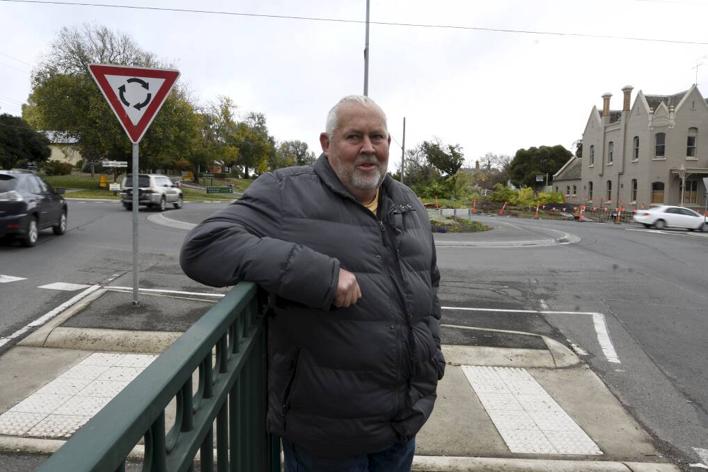 Buninyong resident Brad Mahoney at the roundabout with the crash site in the background. Photo: Lachlan Bence