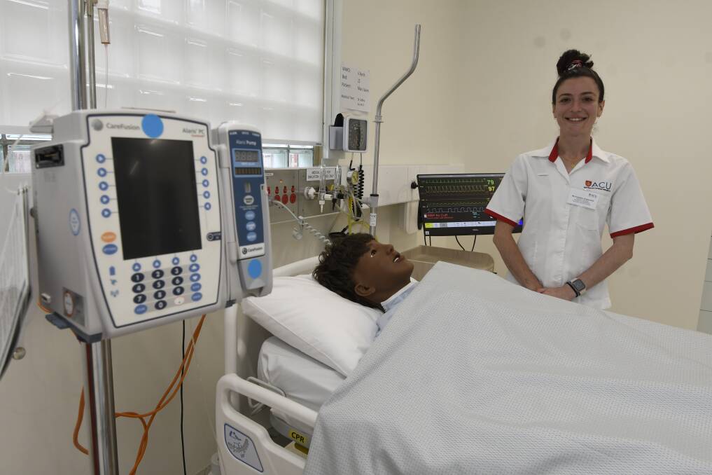 LIFELIKE: ACU fourth year nursing student Anastasia Drapaniotis with one of the new mannequins at the $1.9 million nursing training unit. Picture: Lachlan Bence