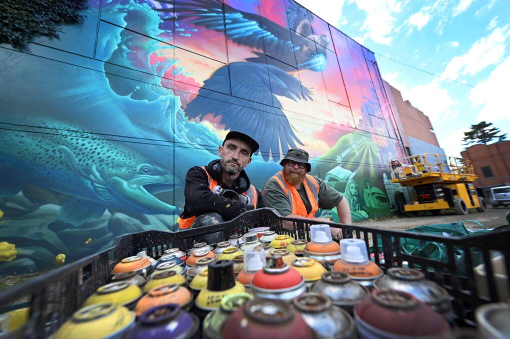Lead artist Chuck Mayfield and assistant artist Cax One with their mural on Field Street. Picture by Lachlan Bence