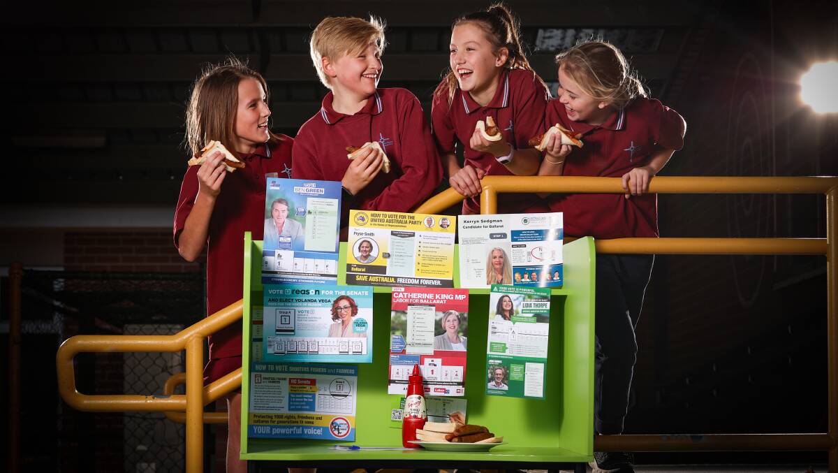 VOTING: St Alipius Parish School students Casper, Charlie, Leni and Winnie with their democracy sausages. Scan the QR code to see Ballarat's voting booths and sausage sizzles. Picture: Luke Hemer.