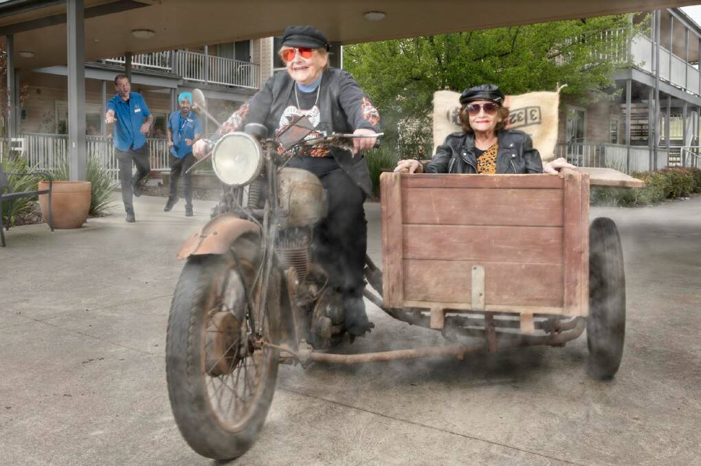 Helen Bridge escapes Hepburn House on a vintage motorbike - while Denise De Zilwa hitches a ride in the box. Hapless staff run after their cloud of smoke. Picture by David White.