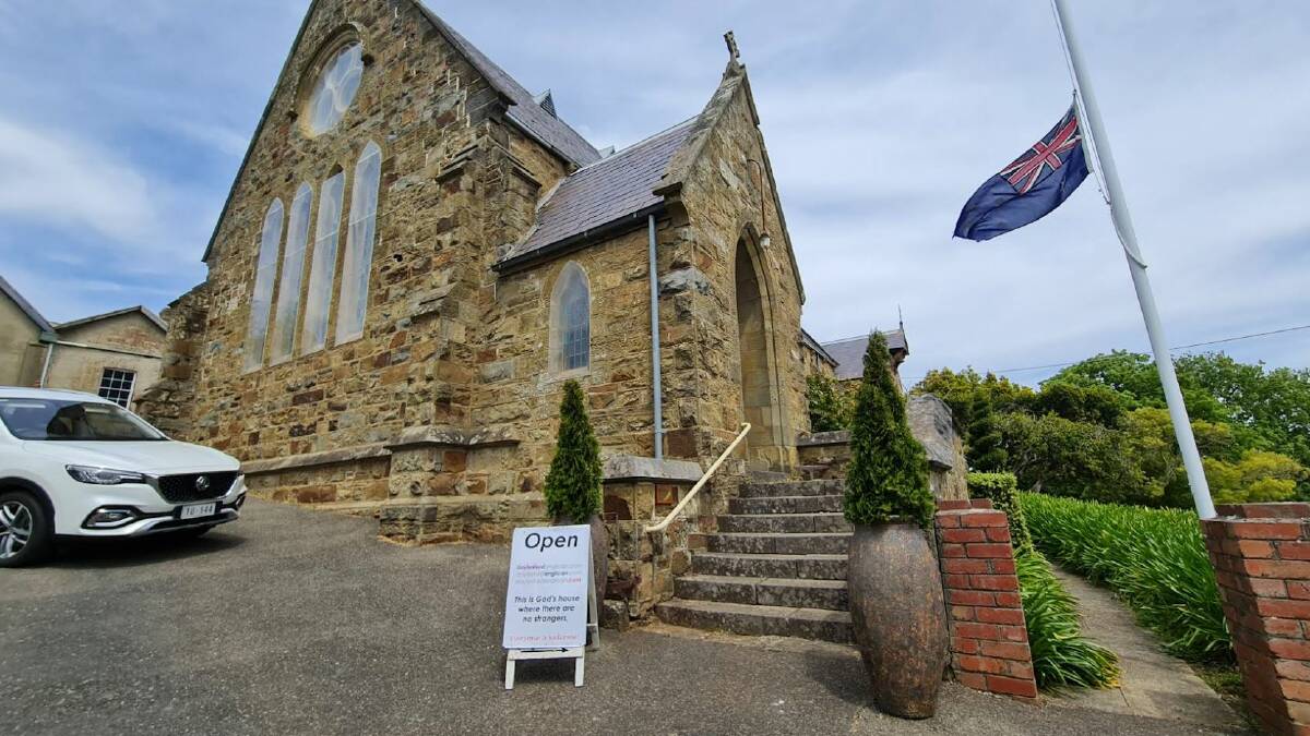 The flag flies at half mast at Daylesford's Anglican church, which has remained open to allow people to light a candle after Sunday's horrific accident. 