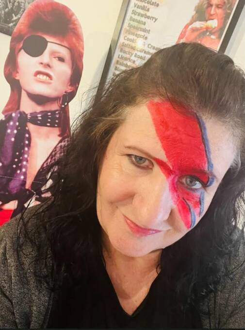Cafe owner Jo Britt with an-almost-life-size cutout of her rock idol David Bowie. Picture supplied.