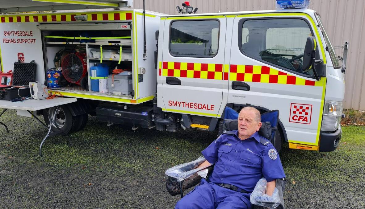 Smythesdale firefighter Wayne Bourke shows how to cool off in a purpose built chair with bags of water. Picture by Gabrielle Hodson.