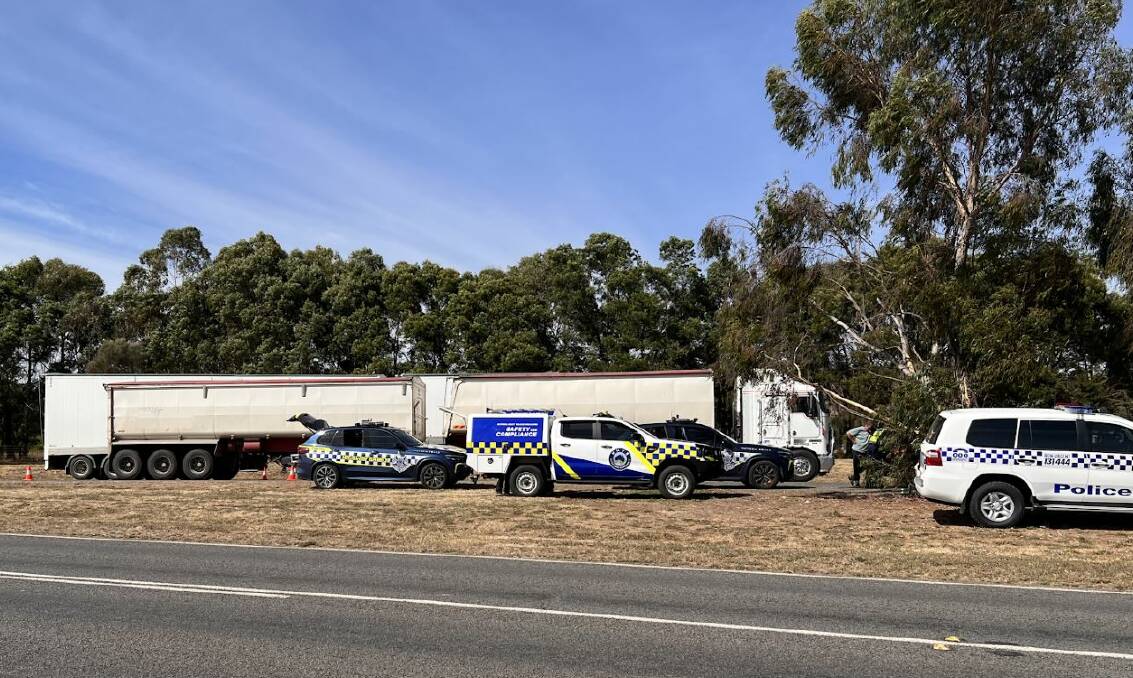 Ballarat Highway Patrol officers and staff from the National Heavy Vehicle Regulator inspect grain trucks beside the Sunraysia Highway at Waubra. Picture by Victoria Police. 