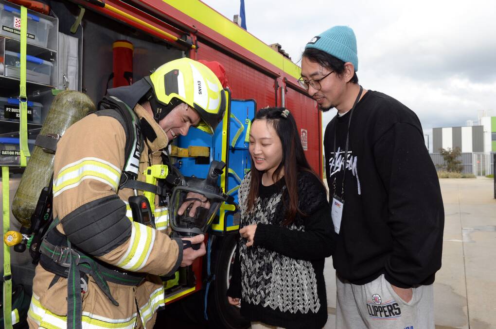 Firefighter Alan Evans showing Jiacheng Yin and Tao Wu the equipment at Lucas Fire Station as part of BRMC's welcome tour around Ballarat. Picture by Kate Healy
