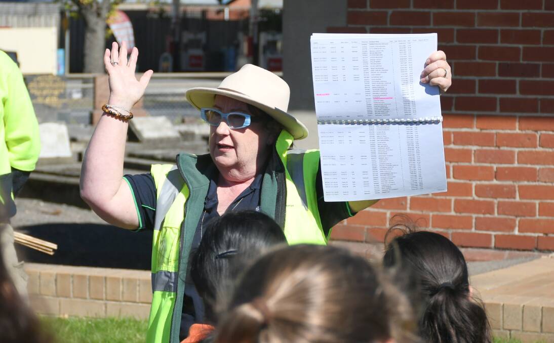 Ballarat Cemeteries Chief Executive Annie De Jong tells students how to place the flags. Picture by Gwen Liu.