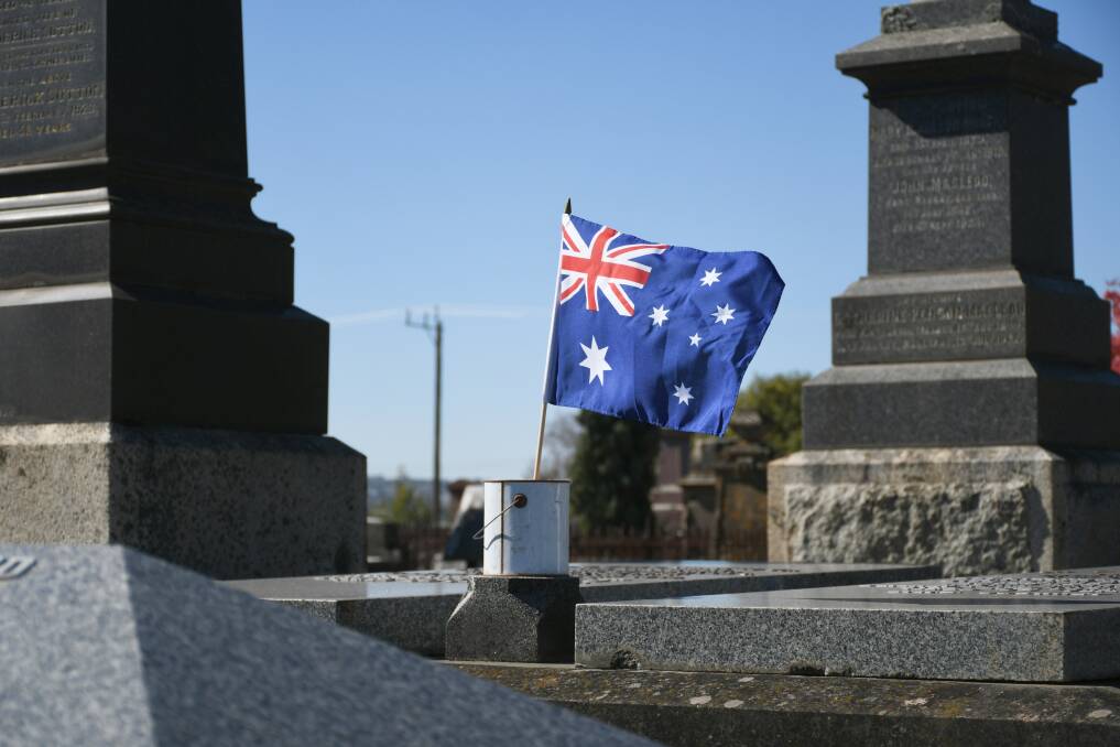 A flag is placed by students in Ballarat Old Cemetery. Picture by Gwen Liu.