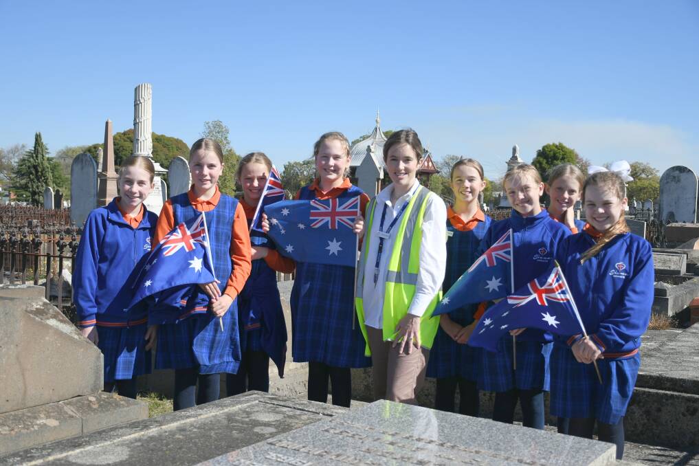 Respect: Georgia Brittain helped students, Chelsea, Sophie, Ava, Amelia, Tayla, Annabelle, Charlie and Pippa place flags in Ballarat Old Cemetery. Picture by Gwen Liu.