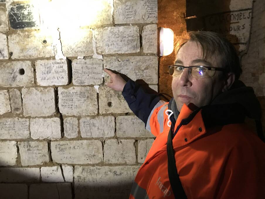 HEROIC HISTORY: French archaeologist Gilles Prilaux points to graffiti in the Naours caves made by Nambour farmer Private William Gage who died at Pozières in 1916  Picture: Michael Grealy

