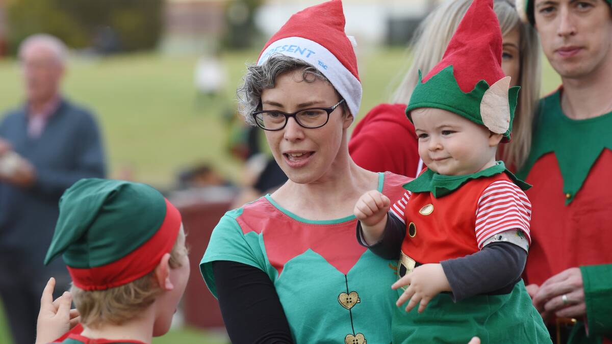 HELPERS: Santa's elves Alisa Walter and Leo Clugston, 1, at the 2018 Carols by Candlelight at Mars Stadium. Picture: Kate Healy