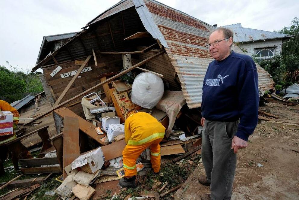 John Hungerford looks over the damage left after a truck crashed through the Newlyn Antique Shop on the Midland Highway in 2012.