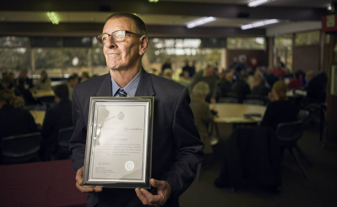 GRACE UNDER PRESSURE: Ian McBain accepts an award from Ballarat police after saving his neighbour's life in a house fire. Picture: Luka Kauzlaric.
