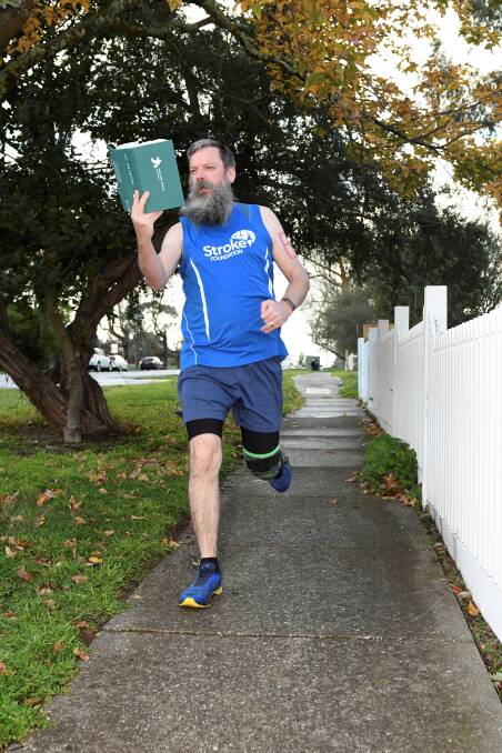 Bob Carey-Grieve reading 'War and Peace' while out training. Along with running, he reads 50 pages a day to keep his mind active. Photo: Lachlan Bence.