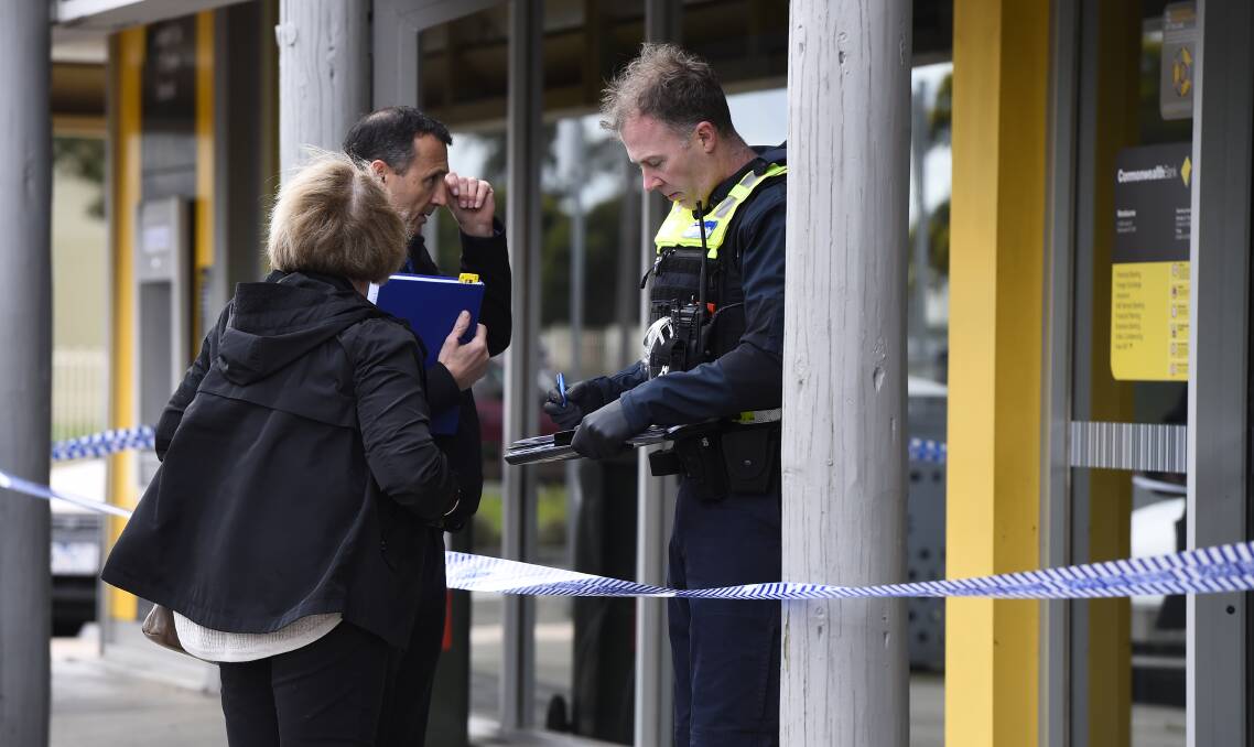 Police conducting interviews out the front of the bank yesterday. Photo: Adam Trafford.