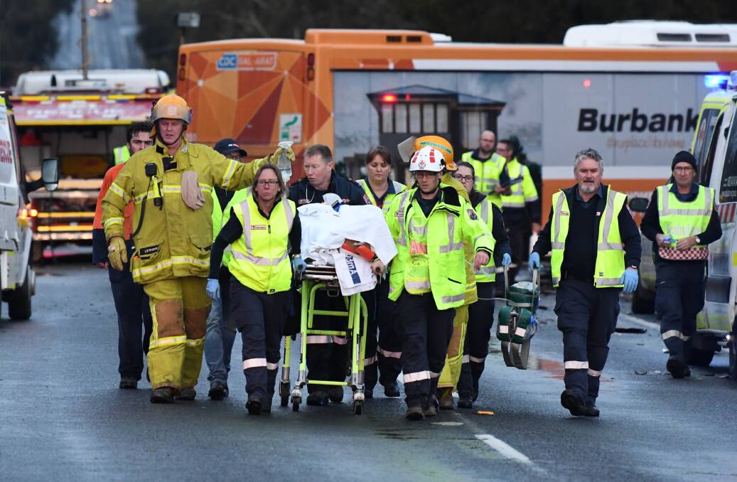 The bus driver being stretchered after being freed from the bus. Photo: Lachlan Bence.