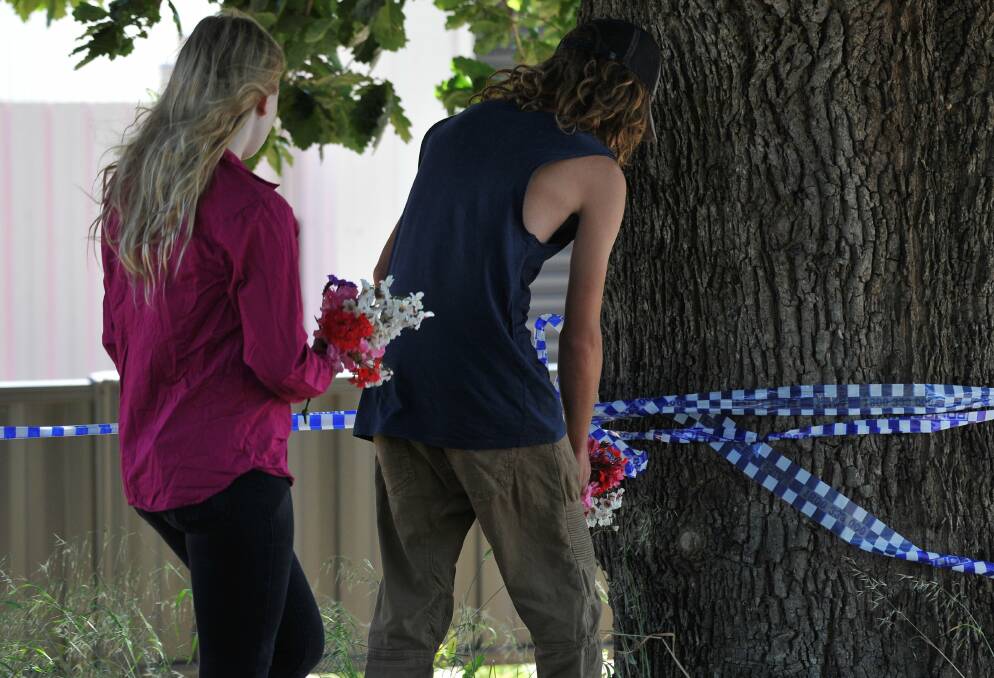 Mourners lay flowers after the crime in 2019.