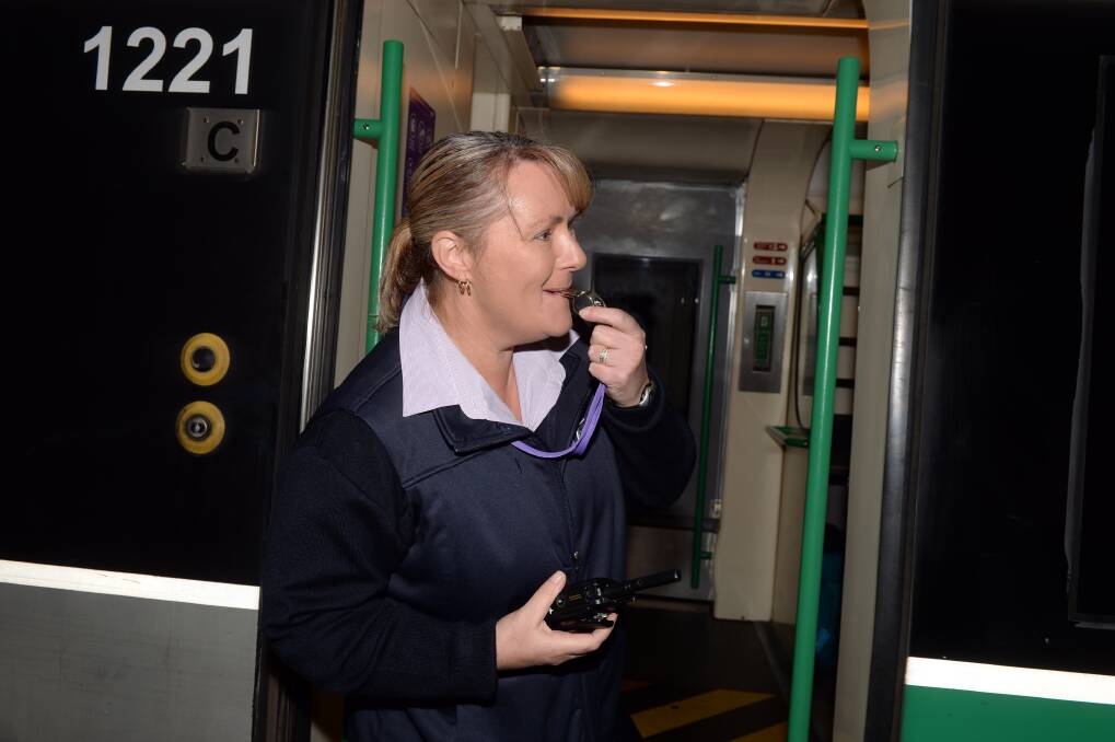 ALL ABOARD: V/Line train conductor Mandy Johns signals commuters the Ballarat train is about to leave the station. Picture: Kate Healy