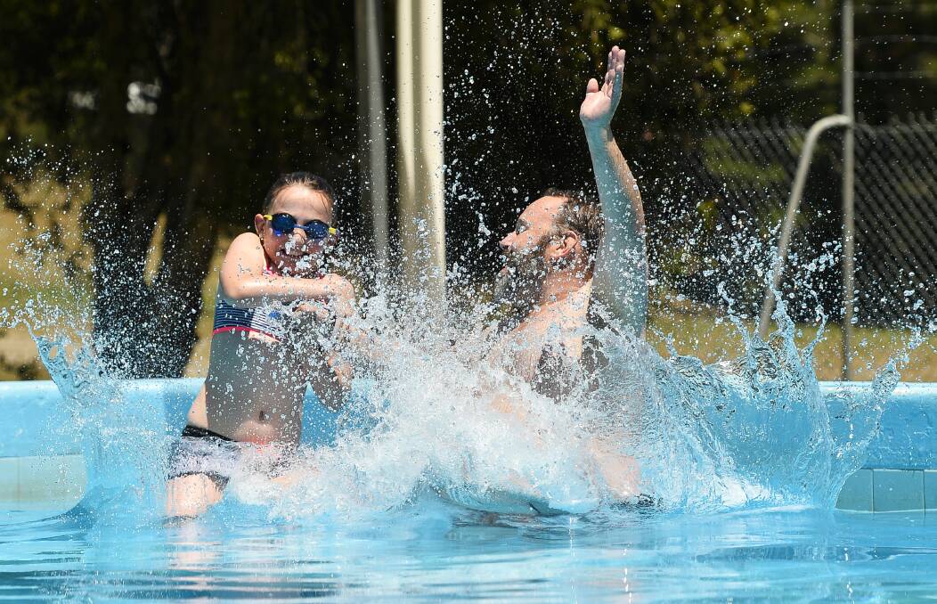 DIVE IN: Wayne Crooks and daughter, Mackenzey, nine, make a splash at the Black Hill Aquatic Centre. Picture: Dylan Burns.