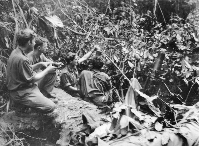 Lance Copland, third from the left, on the mortar at Mount Tambu on July 30, 1943. This picture was taken at the same time as the famous photo of Leslie 'Bull' Allen carrying an American soldier. PICTURE: Gordon Short/Australian War Memorial