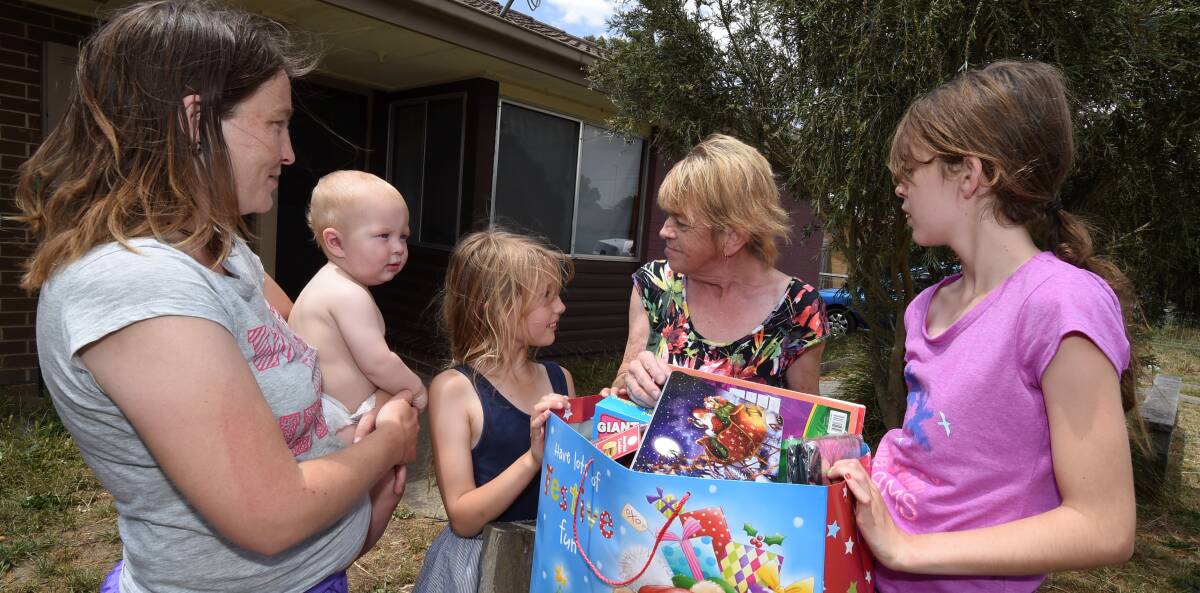 Generosity: Margaret Korosec, second from right, handing gifts to Rebecca Bayer and her three children on Saturday. PICTURE: Lachlan Bence
