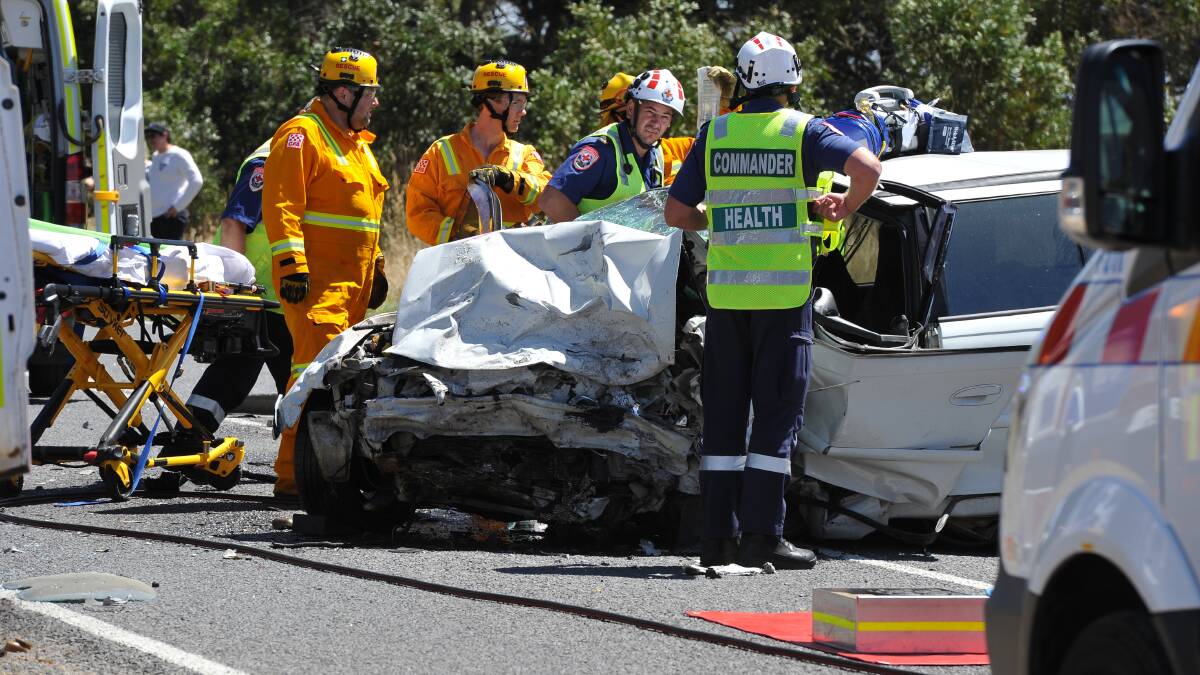 ROAD CLOSED: Emergency services work to free a driver trapped in a two car collision at Waubra this afternoon. Pictures: Lachlan Bence.