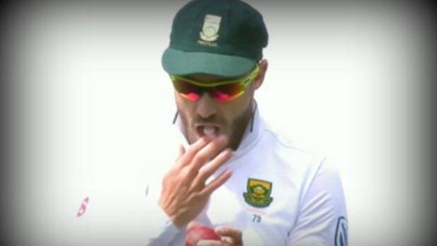 Charged: Faf du Plessis seen rubbing the ball with a mint in his mouth. 
