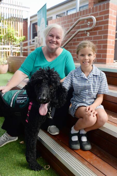 Paw Pals facilitator Kath Anderson and St James' Parish School pupil Tilly, 6, with therapy dog Millie. Picture by Kate Healy
