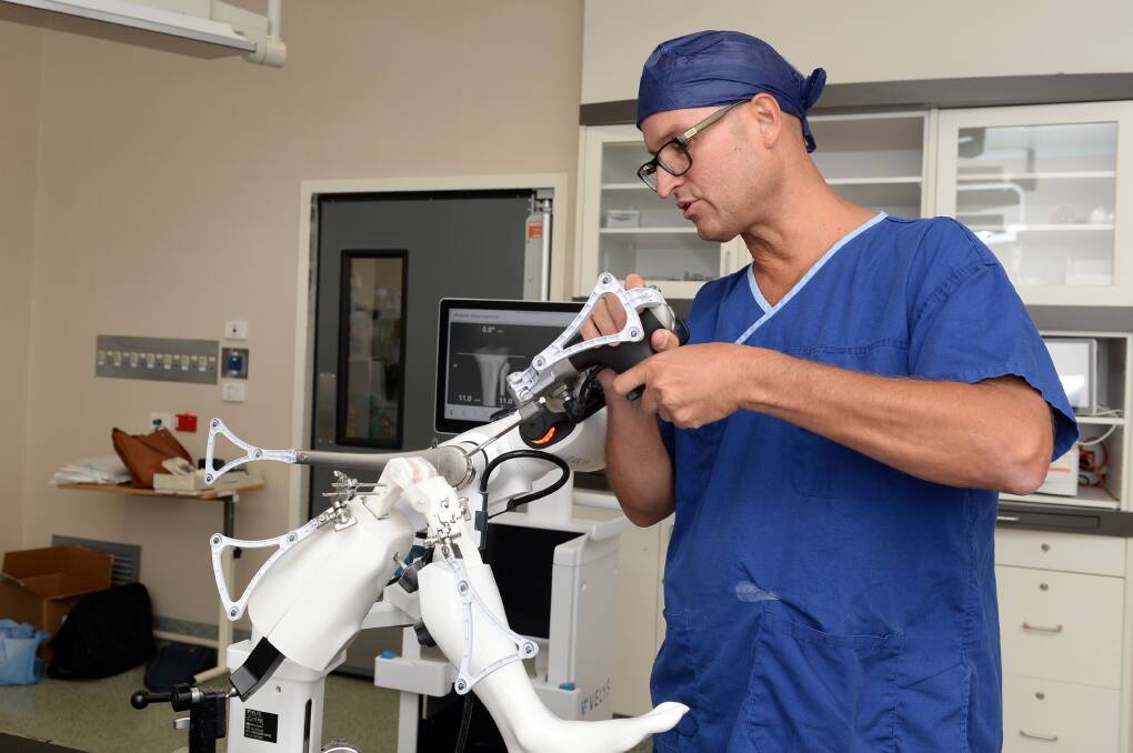 Orthopaedic surgeon Paul Plank in theatre using the new robotic-assisted device. Picture by Kate Healy
