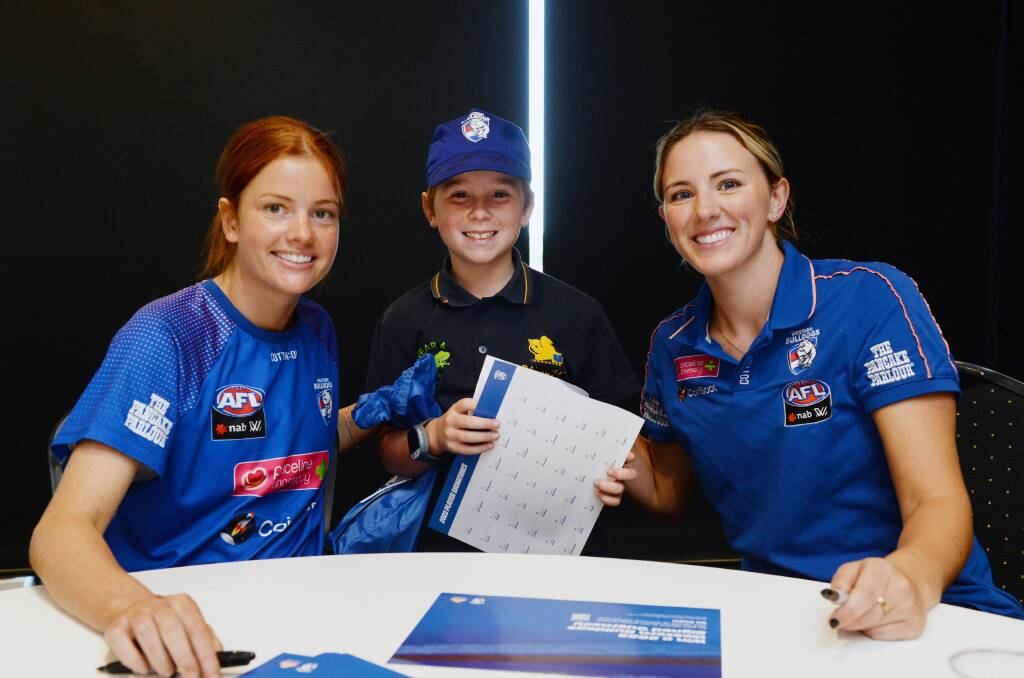 AFLW Western Bulldogs players Eleanor Brown, left, and Gabby Newton, right, with grade four pupil, Lachie, at the Bulldogs Read welcome on Friday. Picture by Kate Healy