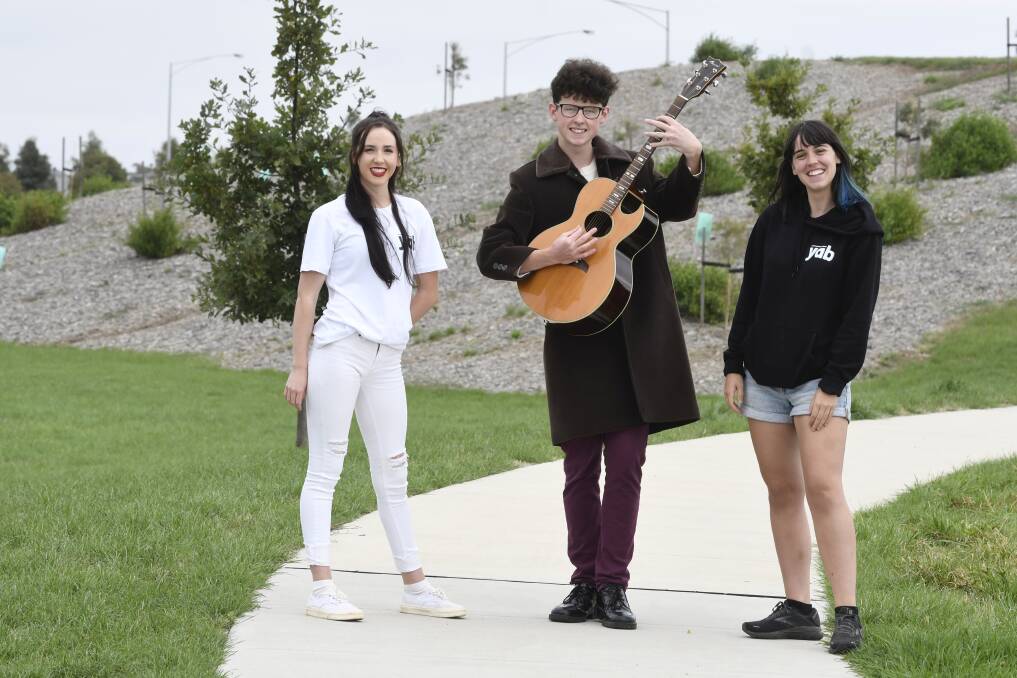 EVENT: Youth Advisory Board members Katie Balharrie, left, and Chloe Waddell, right, meet up at Lucas Central Park with musician Roy Darby, centre, ahead of 'Spring in the Park: Autumn Edition'. Picture: Lachlan Bence 