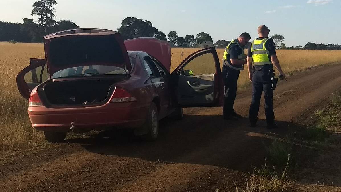 Found: Police with the Ford Fairmont which was at the centre of a police manhunt. Picture: The Standard