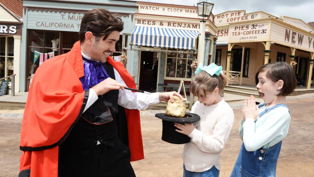 MAGIC TRICK: Ebony Ryan, 9, and Montannah Ryan, 11, with Professor Lux Fernandez (Seth Leslie), who will feature in Sovereign Hill's Magic of Gold summer holiday program. Picture: Kate Healy
