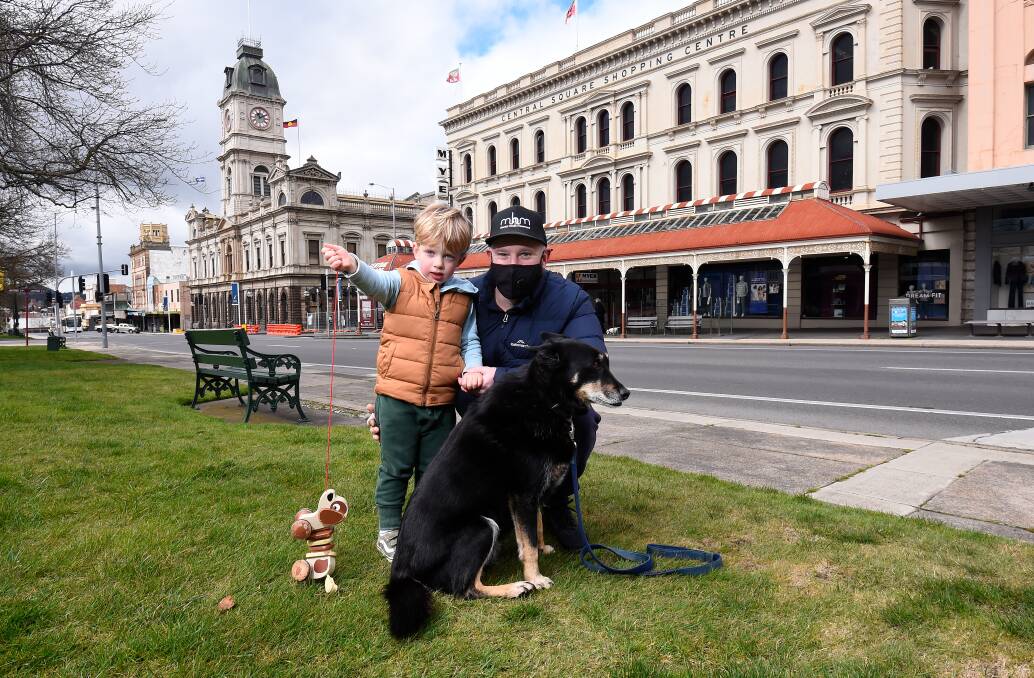 FATHER'S DAY: Leigh Searle with his three-year-old son Henry and dog Rocky were playing hide-and-seek in Sturt Street on Sunday morning. Picture: Adam Trafford