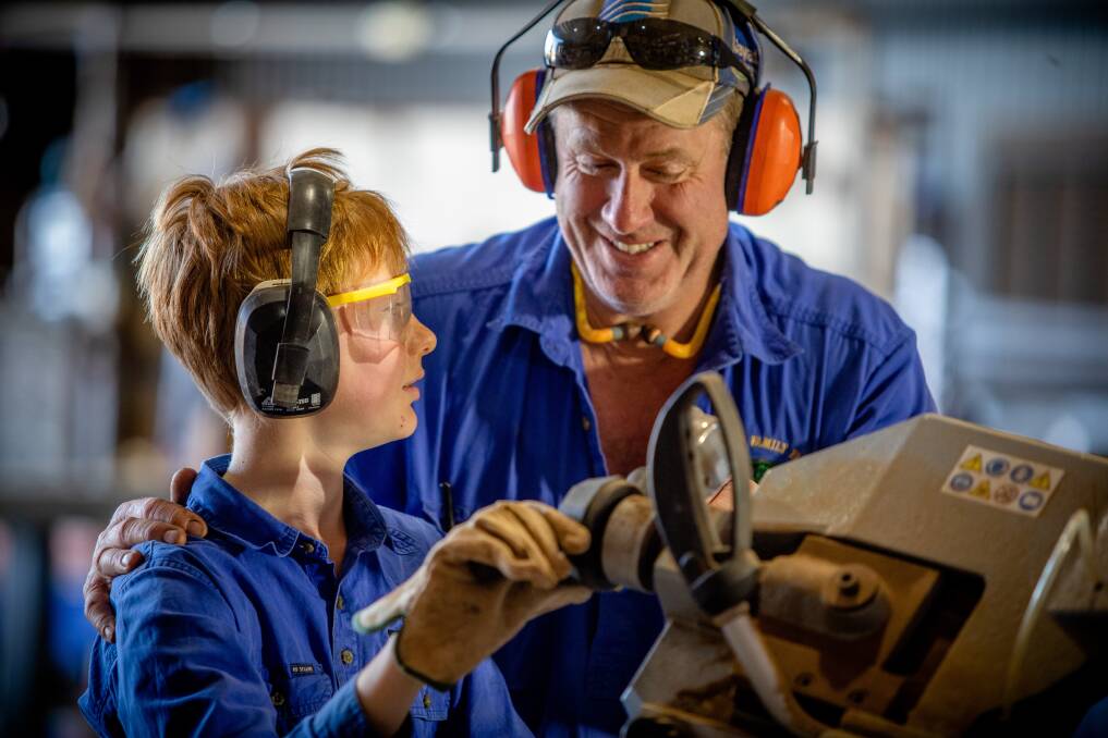 Peter Thompson of Manangatang, pictured with son Luke (12) together in the farm workshop. 