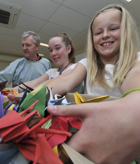 A THOUSAND CRANES: Buninyong Primary School students (from left) Lani Wallace and Phoebe Shaw dig into the cranes they made. Picture: Lachlan Bence 
