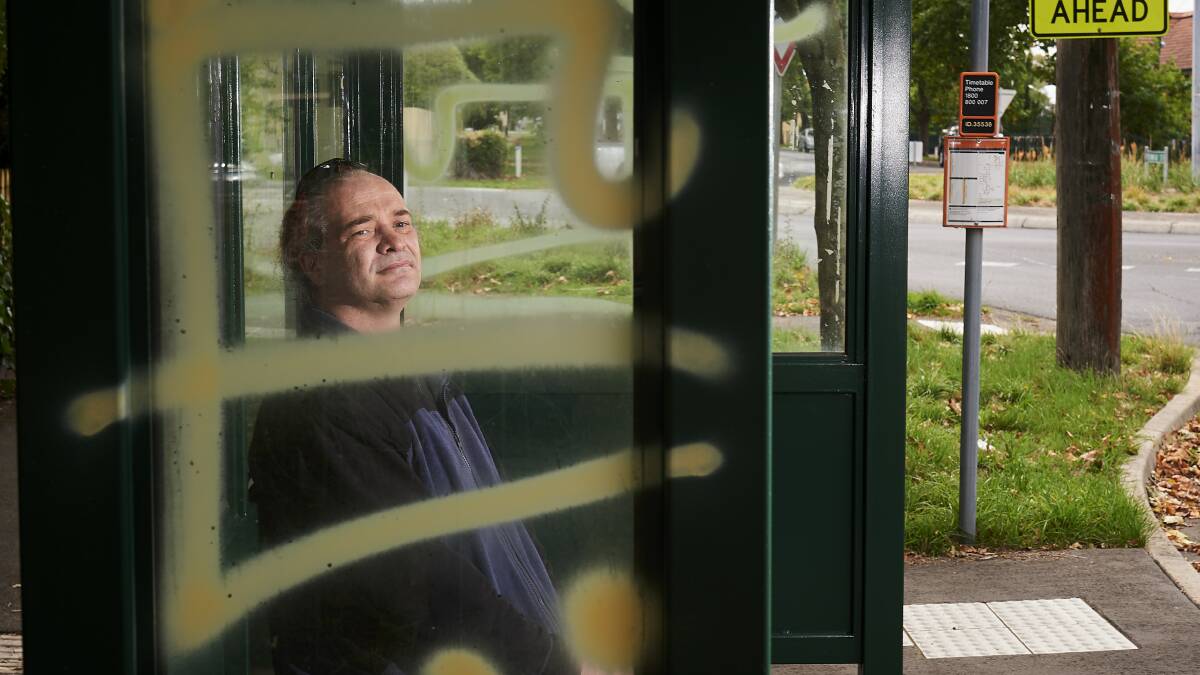 DISAPPOINTING: Jeremy Stapleton at one of the vandalised bus stops on Drummond Street. Picture: Luka Kauzlaric
