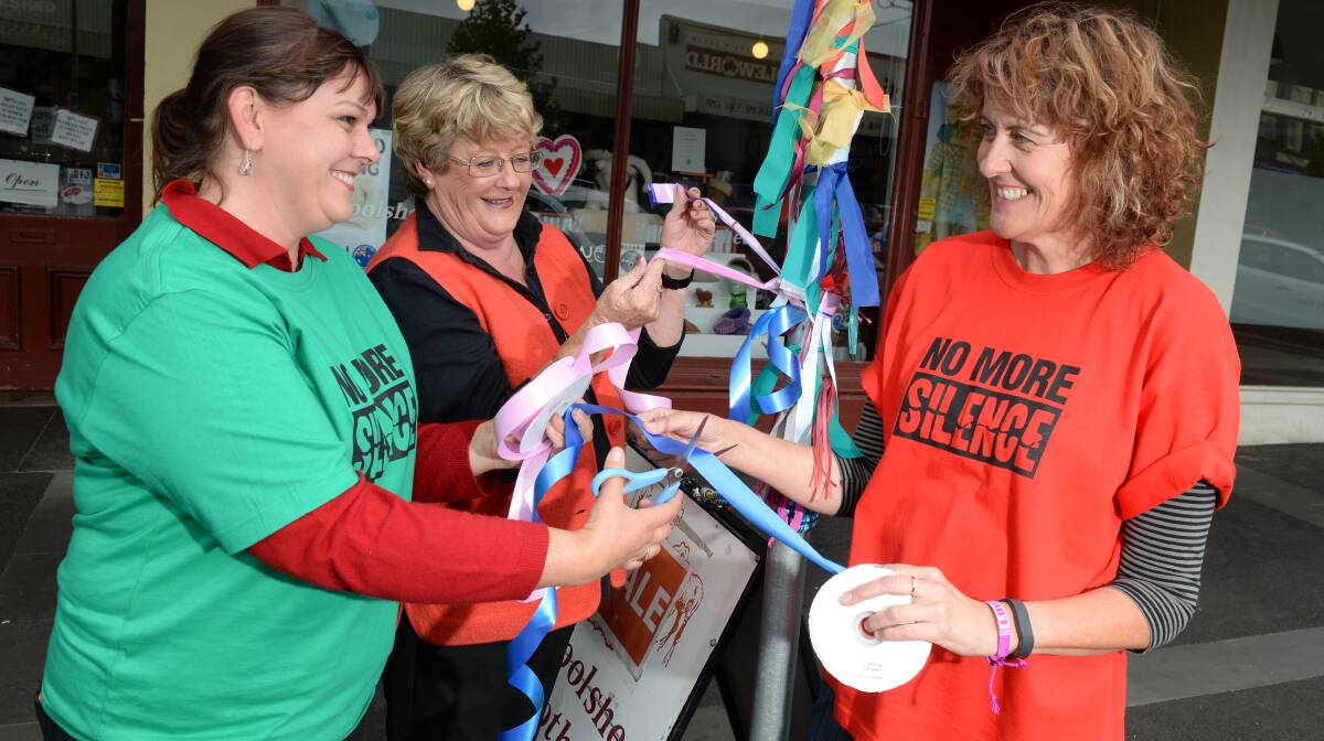 ENDING THE SILENCE: Lou Ridsdale, Pam Sefton and Maureen Hatcher tie ribbons. 