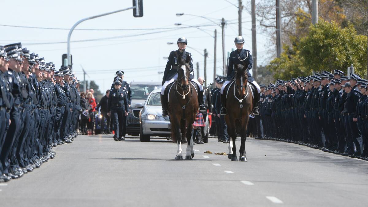 Hundreds of police form a guard of honour along Howitt Street on Thursday to farewell Acting Senior Sergeant Barry Hills. Pictures: Kate Healy 