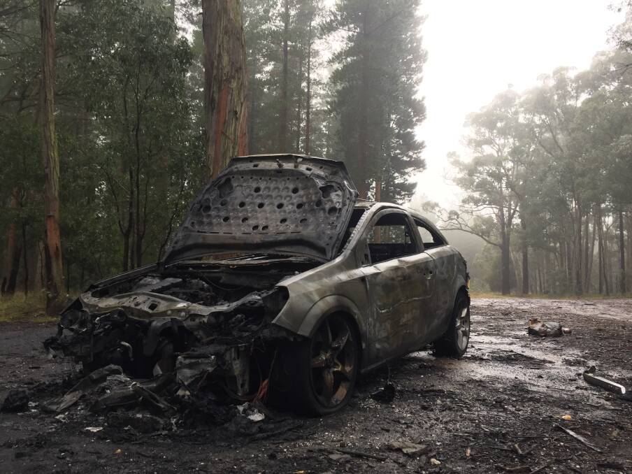 BLACKENED: A burnt hatchback sits idly after it was set alight in a remote pine plantation east of Invermay off White Swan Road about 9.30pm on Thursday.
