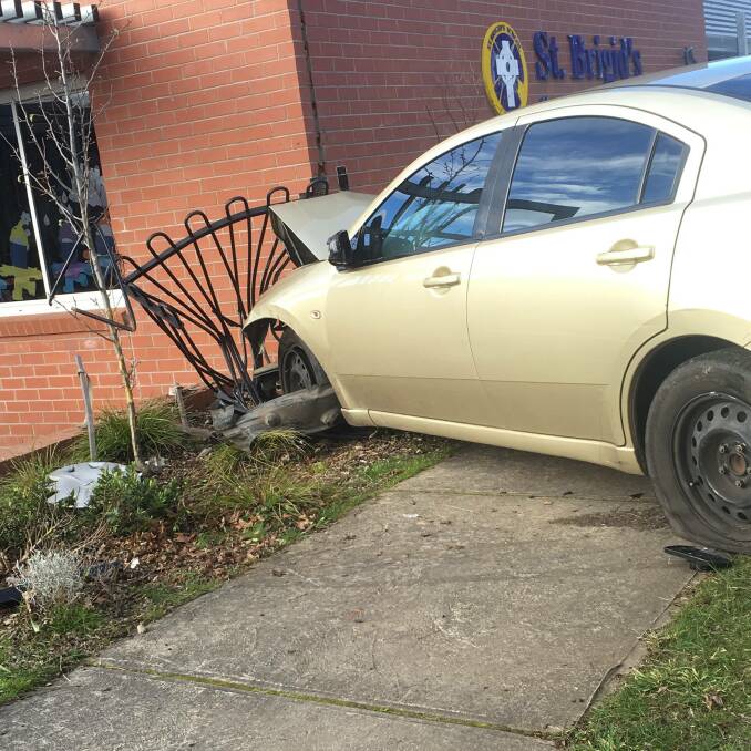 SMASH: An elderly woman driving a gold sedan lost control and crashed into a brick wall of St Brigid's Primary School in Ballan, requiring experts to inspect the building's safety on Wednesday. Picture: Moorabool News